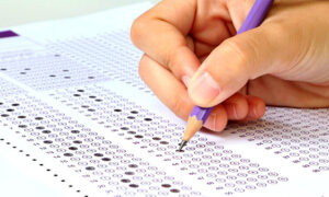Candidato preenchendo gabarito da prova de concurso público. lei dos concursos