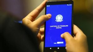 Foto de trabalhador acessando app da carteira de trabalho pelo celular